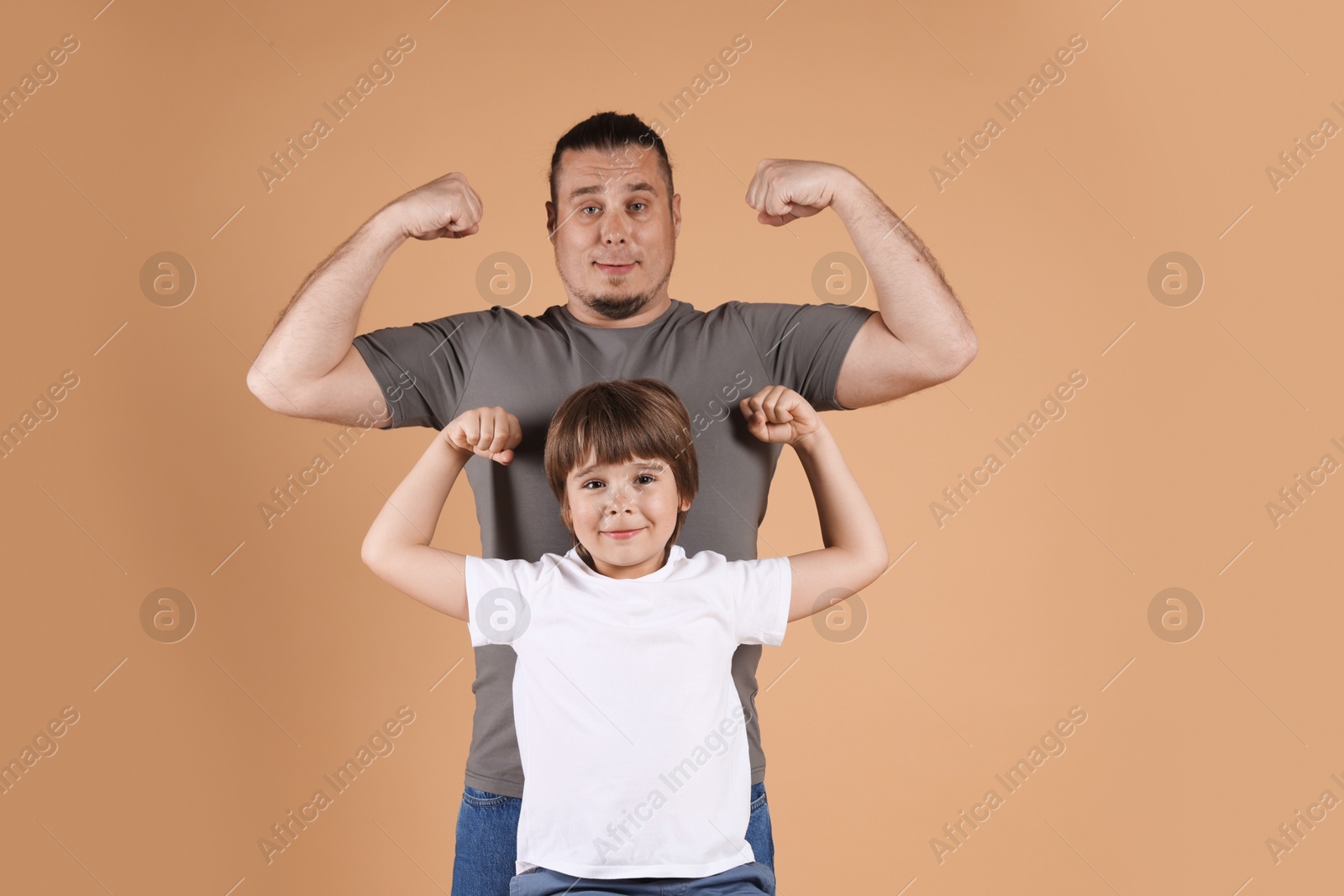 Father and his son on beige background Photo of Father and his son on beige background