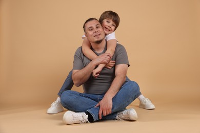 Photo of Father and his son on beige background
