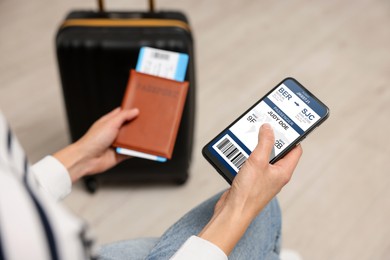 Image of Tourist holding mobile phone with e-ticket for airplane and passport indoors, closeup