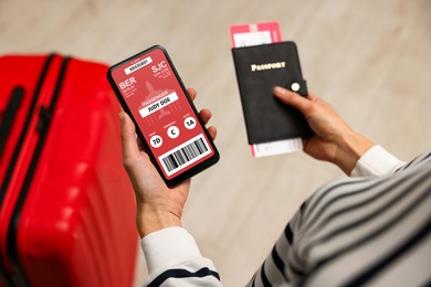 Image of Tourist holding mobile phone with e-ticket for airplane and passport indoors, closeup