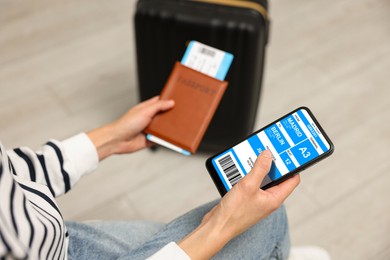 Image of Tourist holding mobile phone with e-ticket for bus and passport indoors, closeup
