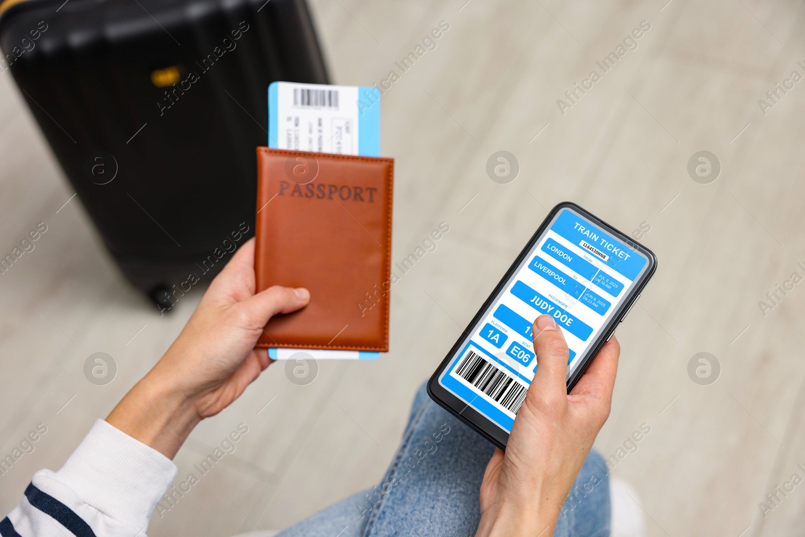 Tourist holding mobile phone with e-ticket for train and passport indoors, closeup Image of Tourist holding mobile phone with e-ticket for train and passport indoors, closeup