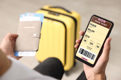 Image of Tourist holding mobile phone with e-ticket for train and passport indoors, closeup