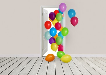 Image of Many bright balloons flying into open door. Festive decoration for birthday party or other celebration