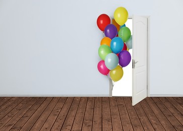 Image of Many bright balloons flying into open door. Festive decoration for birthday party or other celebration