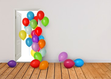 Image of Many bright balloons flying into open door. Festive decoration for birthday party or other celebration