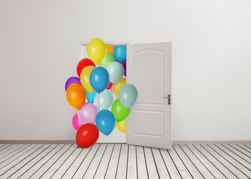 Image of Many bright balloons flying into open door. Festive decoration for birthday party or other celebration