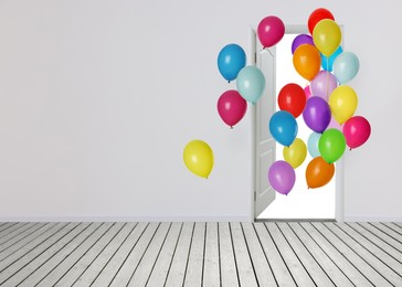 Image of Many bright balloons flying into open door. Festive decoration for birthday party or other celebration