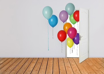 Image of Many bright balloons flying into open door. Festive decoration for birthday party or other celebration