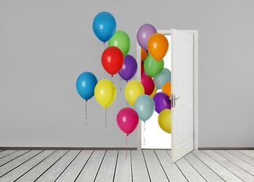 Image of Many bright balloons flying into open door. Festive decoration for birthday party or other celebration