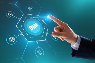 Image of Building information modeling. Man using virtual screen with abbreviation BIM and different icons, closeup