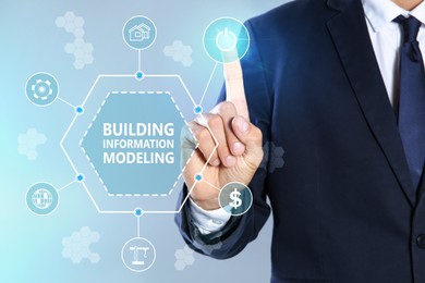 Image of Building information modeling. Man using virtual screen with different icons, closeup