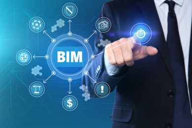 Image of Building information modeling. Man using virtual screen with abbreviation BIM and different icons, closeup