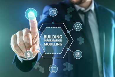 Image of Building information modeling. Man using virtual screen with different icons, closeup