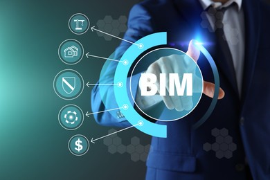 Image of Building information modeling. Man using virtual screen with abbreviation BIM and different icons, closeup
