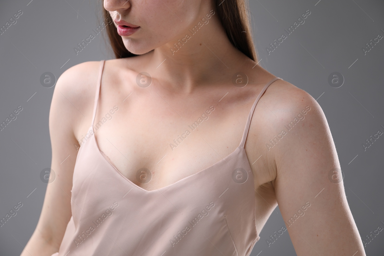 Woman with beautiful collarbones on grey background, closeup Photo of Woman with beautiful collarbones on grey background, closeup