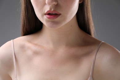 Photo of Woman with beautiful collarbones on grey background, closeup