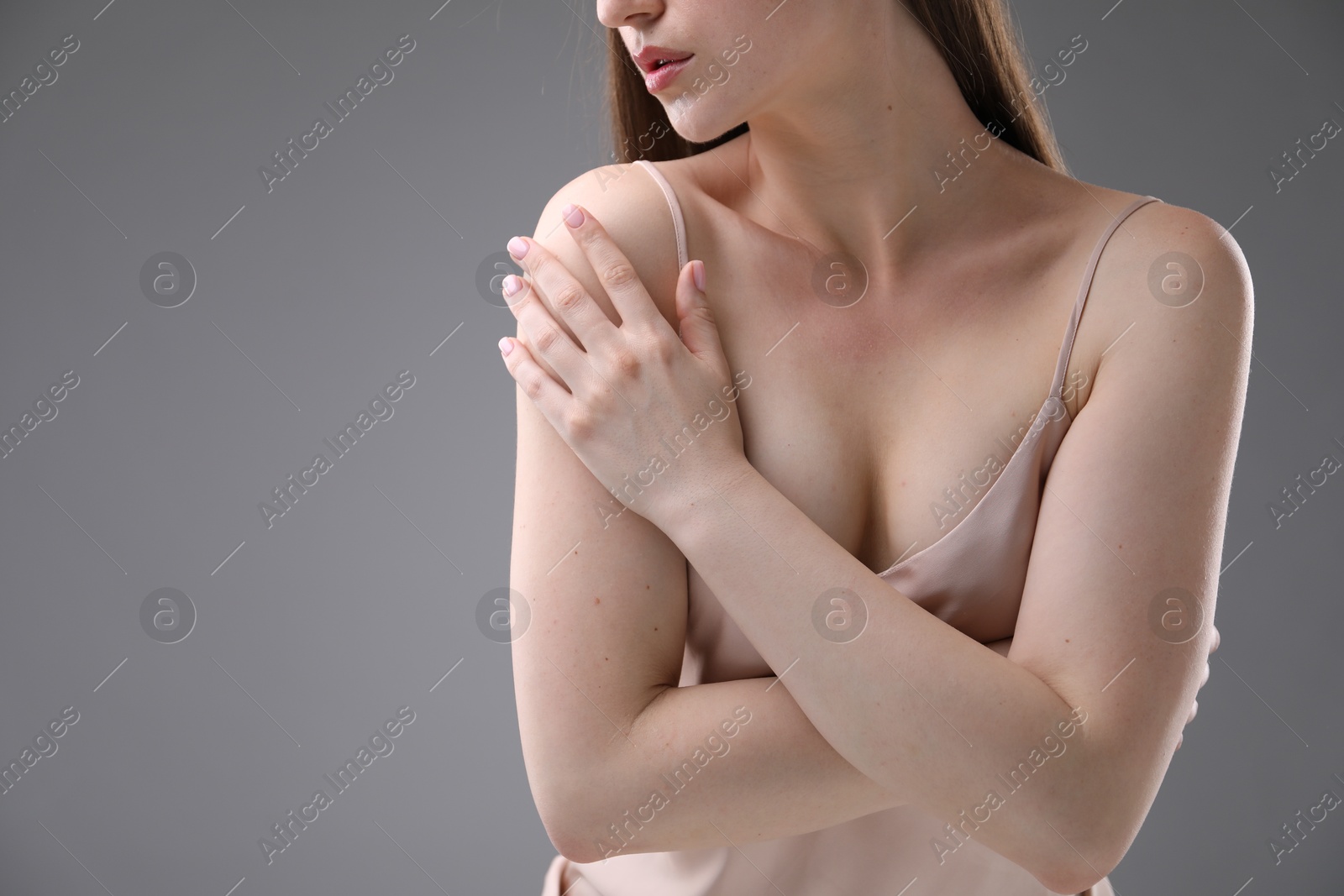Woman with beautiful collarbones on grey background, closeup. Space for text Photo of Woman with beautiful collarbones on grey background, closeup. Space for text