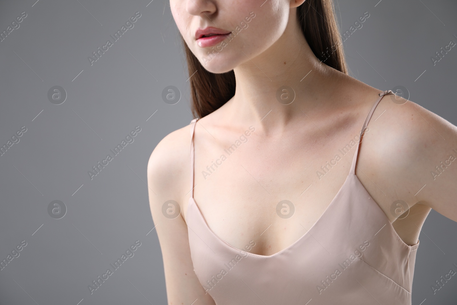 Woman with beautiful collarbones on grey background, closeup Photo of Woman with beautiful collarbones on grey background, closeup