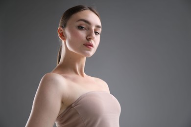 Photo of Portrait of beautiful woman on grey background. Space for text