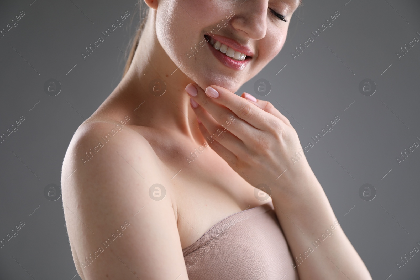 Attractive woman against grey background, closeup on shoulder Photo of Attractive woman against grey background, closeup on shoulder