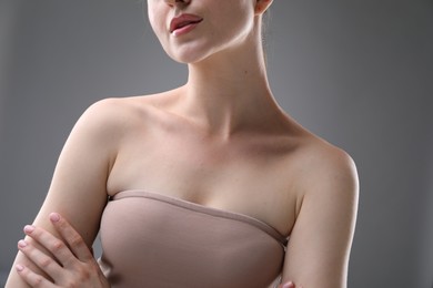 Photo of Woman with beautiful collarbones and neck on grey background, closeup