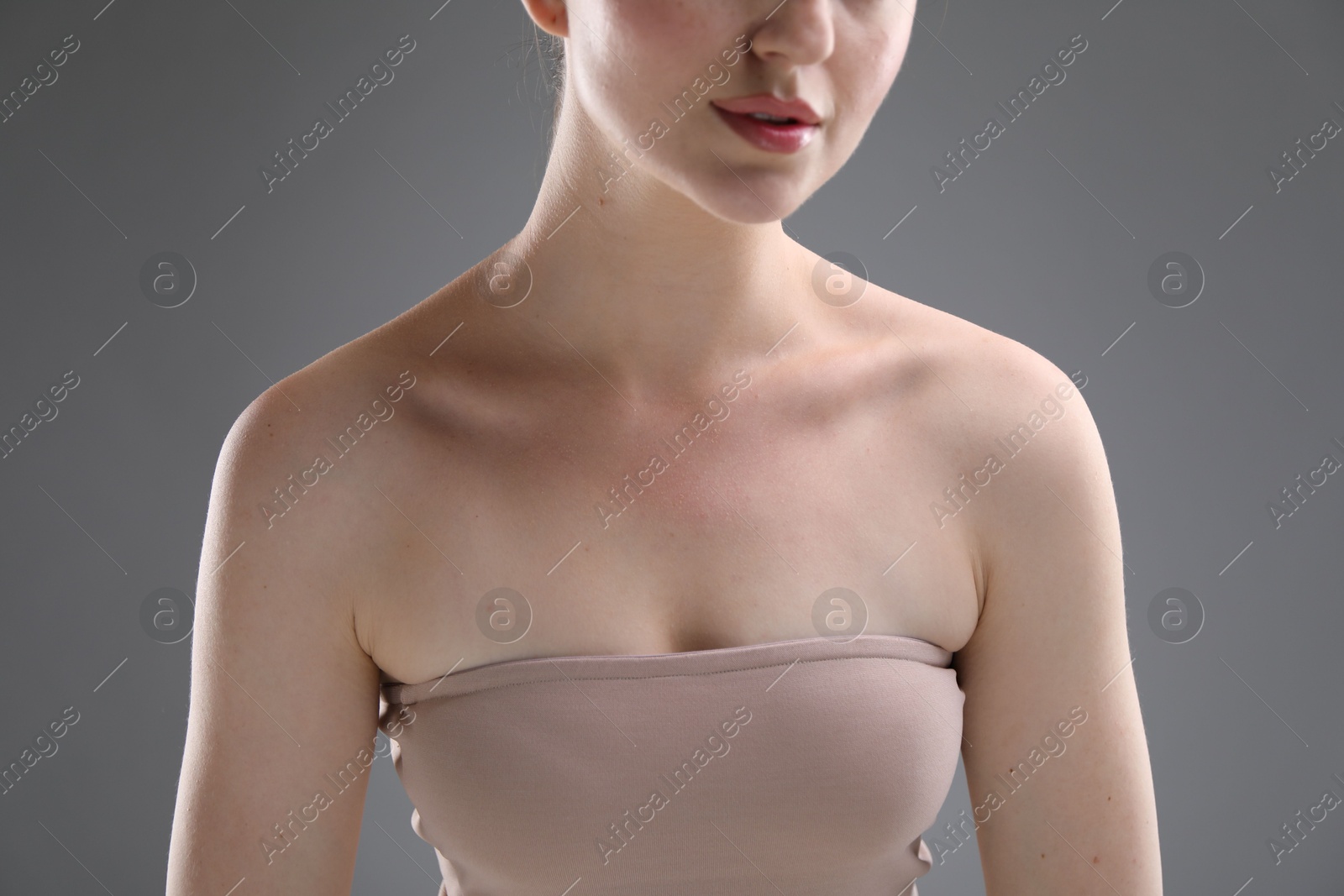 Woman with beautiful collarbones on grey background, closeup Photo of Woman with beautiful collarbones on grey background, closeup