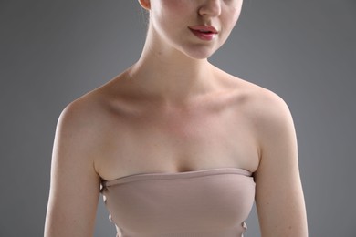 Photo of Woman with beautiful collarbones on grey background, closeup