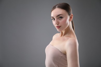 Photo of Portrait of beautiful woman on grey background. Space for text