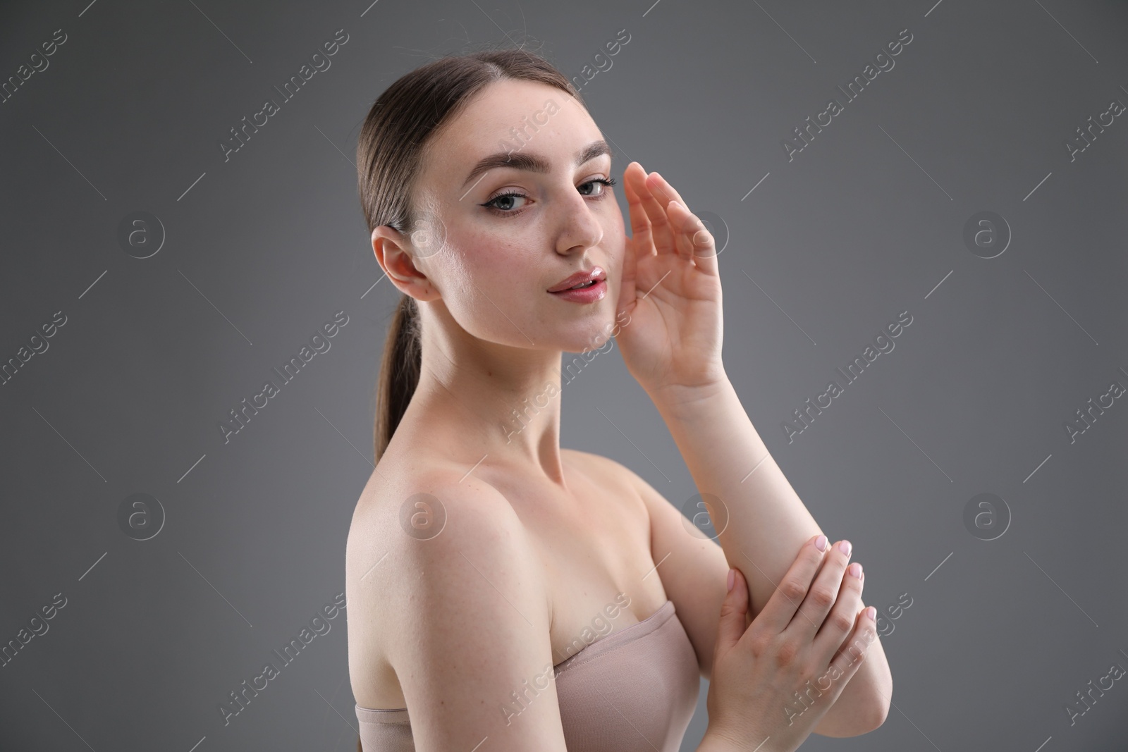 Portrait of beautiful woman on grey background Photo of Portrait of beautiful woman on grey background