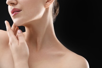 Photo of Woman with beautiful collarbones and neck on black background, closeup