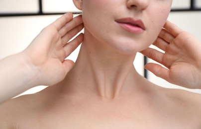 Photo of Woman with beautiful neck on light background, closeup