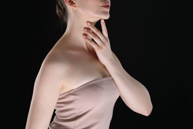 Photo of Woman with beautiful collarbones and neck on black background, closeup