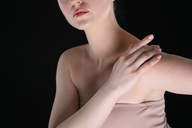 Photo of Woman with beautiful collarbones and neck on black background, closeup