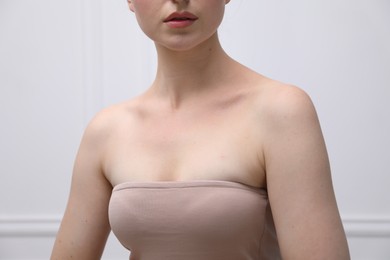 Photo of Woman with beautiful collarbones on light background, closeup
