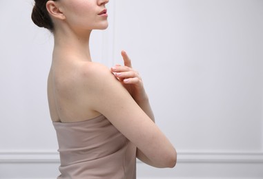 Photo of Attractive woman against light background, closeup on shoulder. Space for text