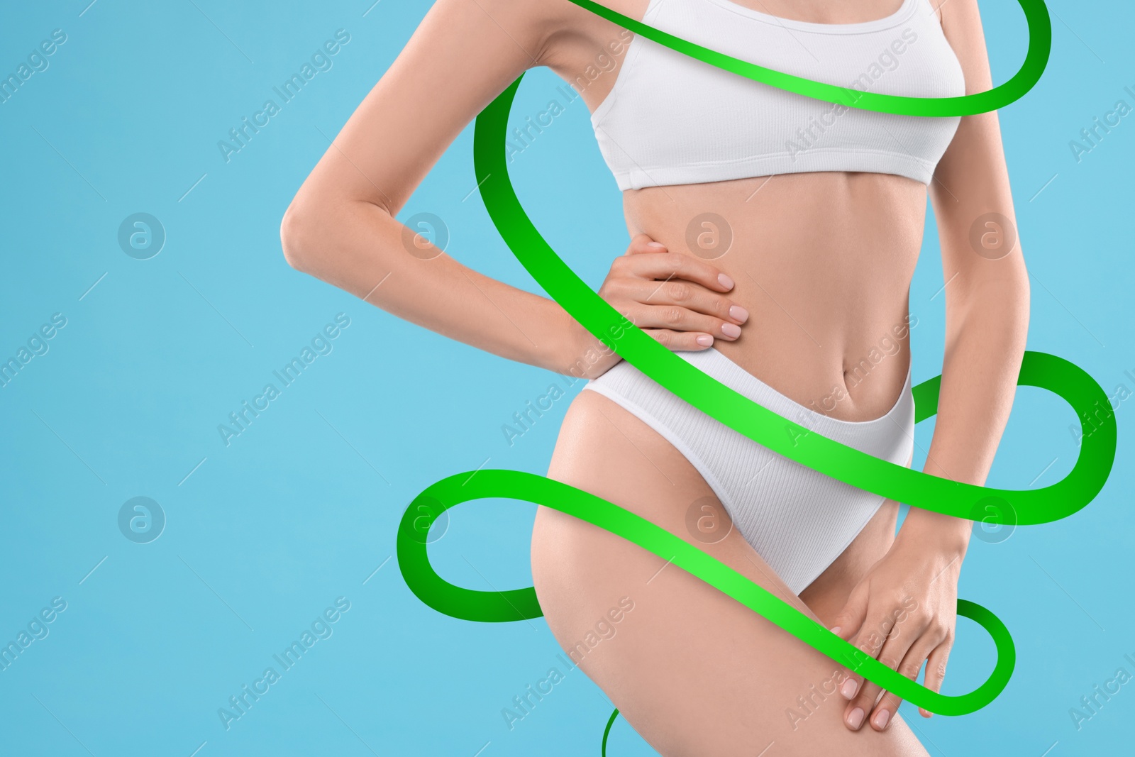 Beautiful woman with perfect figure on light blue background, closeup. Ribbon around her body. Result of healthy lifestyle, diet, sport trainings Image of Beautiful woman with perfect figure on light blue background, closeup. Ribbon around her body. Result of healthy lifestyle, diet, sport trainings