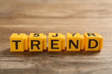 Image of Word Trend made of yellow cubes with letters on wooden table