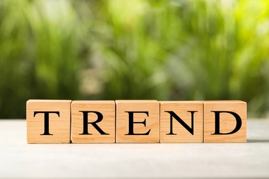 Image of Word Trend made of wooden cubes with letters on table outdoors