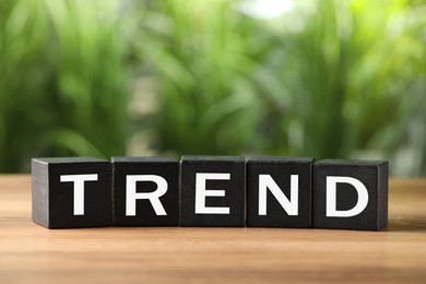 Image of Word Trend made of wooden cubes with letters on table outdoors