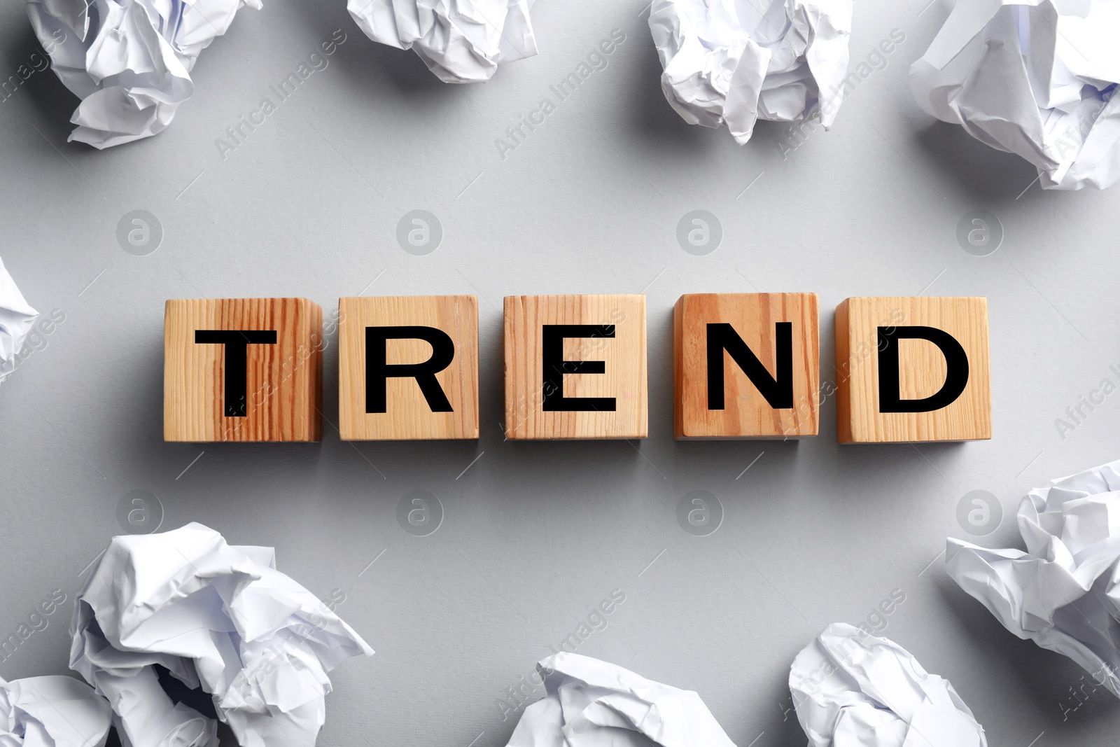 Word Trend made of wooden cubes with letters and crumpled paper balls on light grey background, top view Image of Word Trend made of wooden cubes with letters and crumpled paper balls on light grey background, top view
