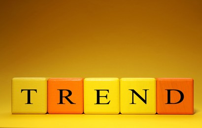 Image of Word Trend made of colorful cubes with letters on yellow gradient background