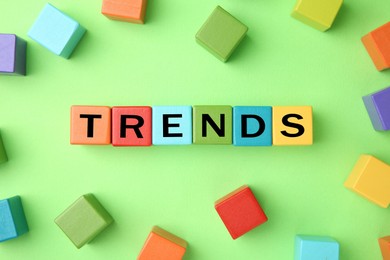 Image of Word Trends made of wooden cubes with letters on light green background, top view