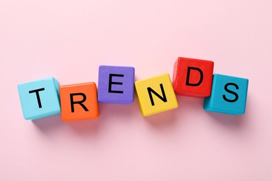 Image of Word Trends made of colorful cubes with letters on pink background, top view