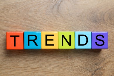 Image of Word Trends made of colorful cubes with letters on wooden background, top view