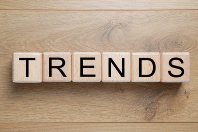 Image of Word Trends made of cubes with letters on wooden background, top view