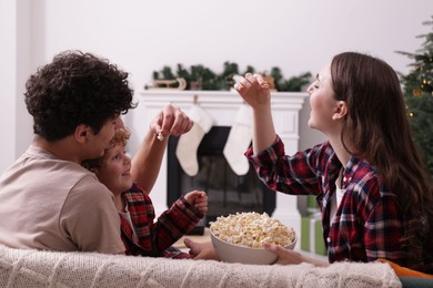 Photo of Family with popcorn spending time together at home. Watching movie via video projector