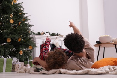 Photo of Family watching movie via video projector at home, back view