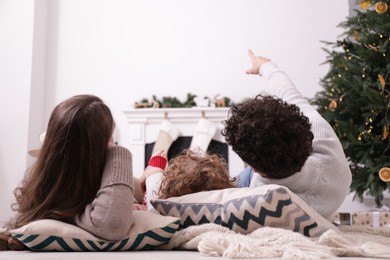 Photo of Family watching movie via video projector at home, back view