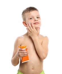 Photo of Little boy with tube applying sun protection cream onto his skin on white background